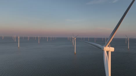 wind turbines, close up, aerial view, clean energy on water, offshore, wind park, sunset. climate change solution. aerial view.