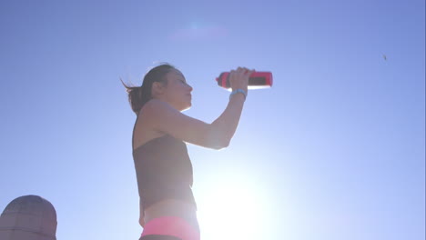 Mujer-Corredora-Refrescándose-Con-Una-Botella-De-Agua.