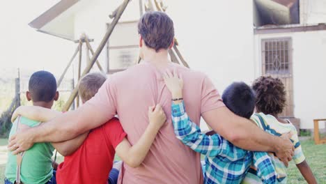 man with kids sitting in the backyard of house 4k