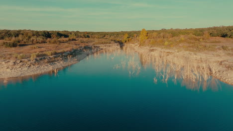 lake georgetown overlook park aerial push in over trees growing out of water, sunset drone flight in austin, texas suburb