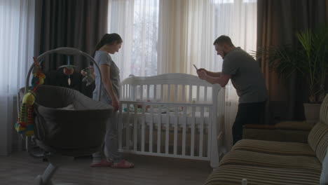 parents looking at their newborn baby in a crib