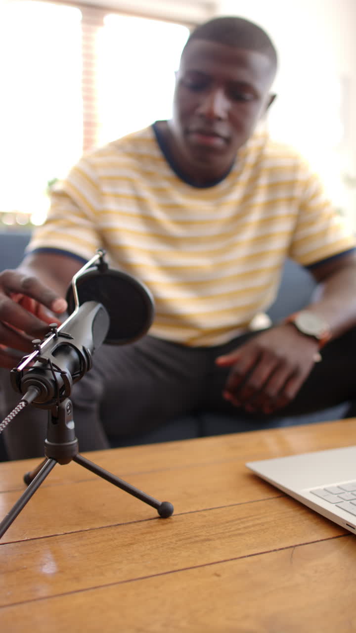 Vertical video: Podcast recording at home, man engaging with microphone and laptop