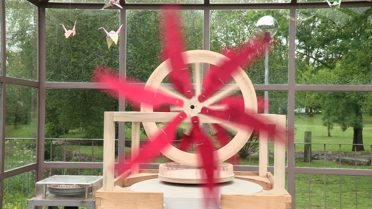 빨간색 나선이 회전하면서 캐스터 밀의 돌을 움직이게 하는 예술적인 목조 구조