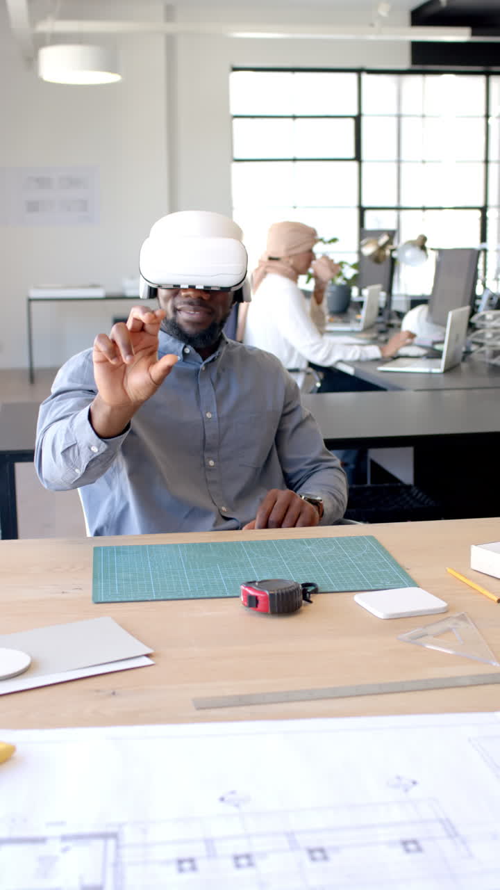 Vertical video: Using VR headset, man interacting with virtual interface in modern office