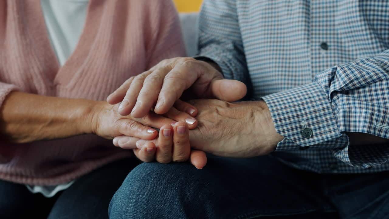 una pareja de ancianos tomados de la mano.
