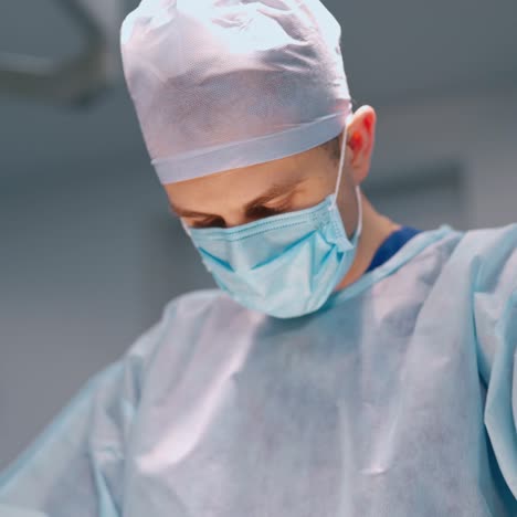 doctor in medical uniform in the operating room. profesional surgeon in medical mask performing a surgery together with a nurse.