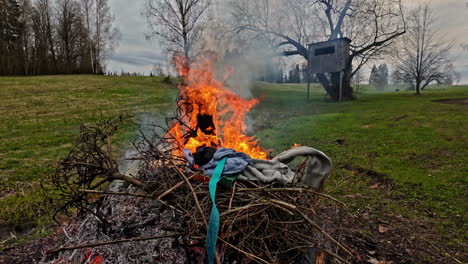 burning brush and old clothing in the countryside - no people bush in slow motion