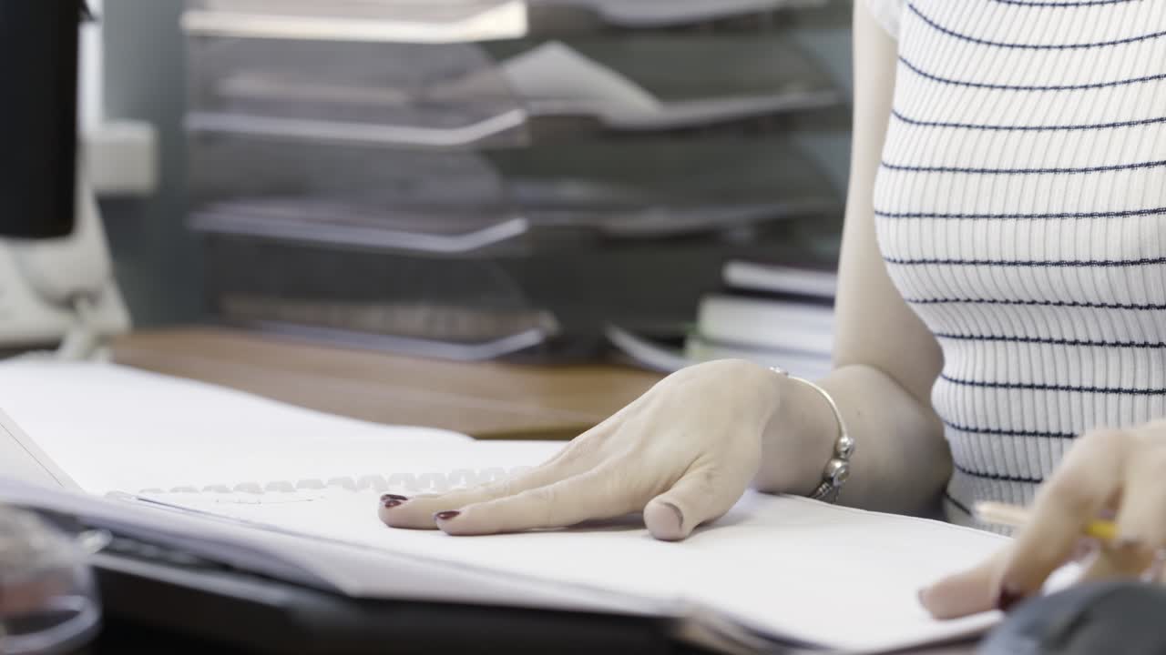 Woman reviewing blueprints in an office