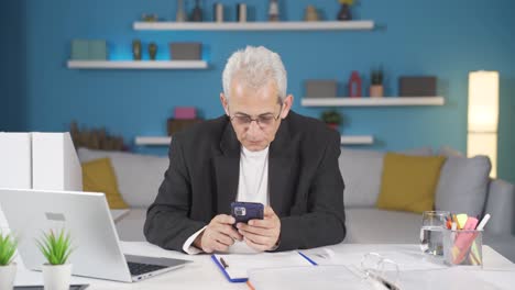 Man-working-from-home-enjoys-mobile-apps-on-phone.