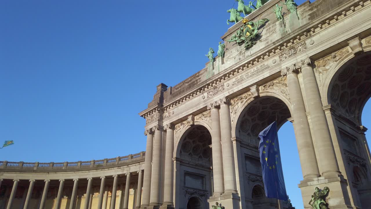 Kite flying above EU flag at Cinquantenaire arch in slow motion