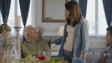 Un-Anciano-Feliz-Y-Su-Hijo-Adulto-Sentados-En-La-Mesa-Y-Hablando-Con-Los-Niños-A-Su-Lado