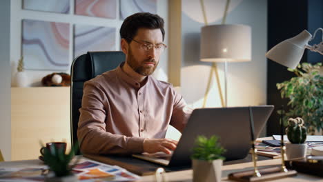 focused businessman working laptop in office close up. worker surfing internet.