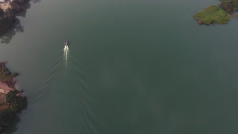 Areal-view-of-boat-cruising-along-the-Volta-river-in-Ghana-with-mangroves-surrounding