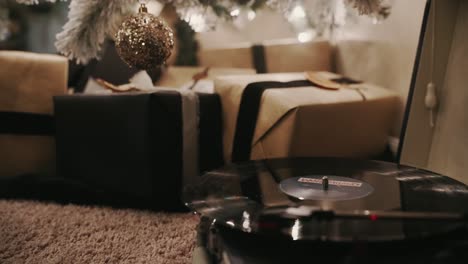 record player christmas music and then panning up to show presents under a christmas tree