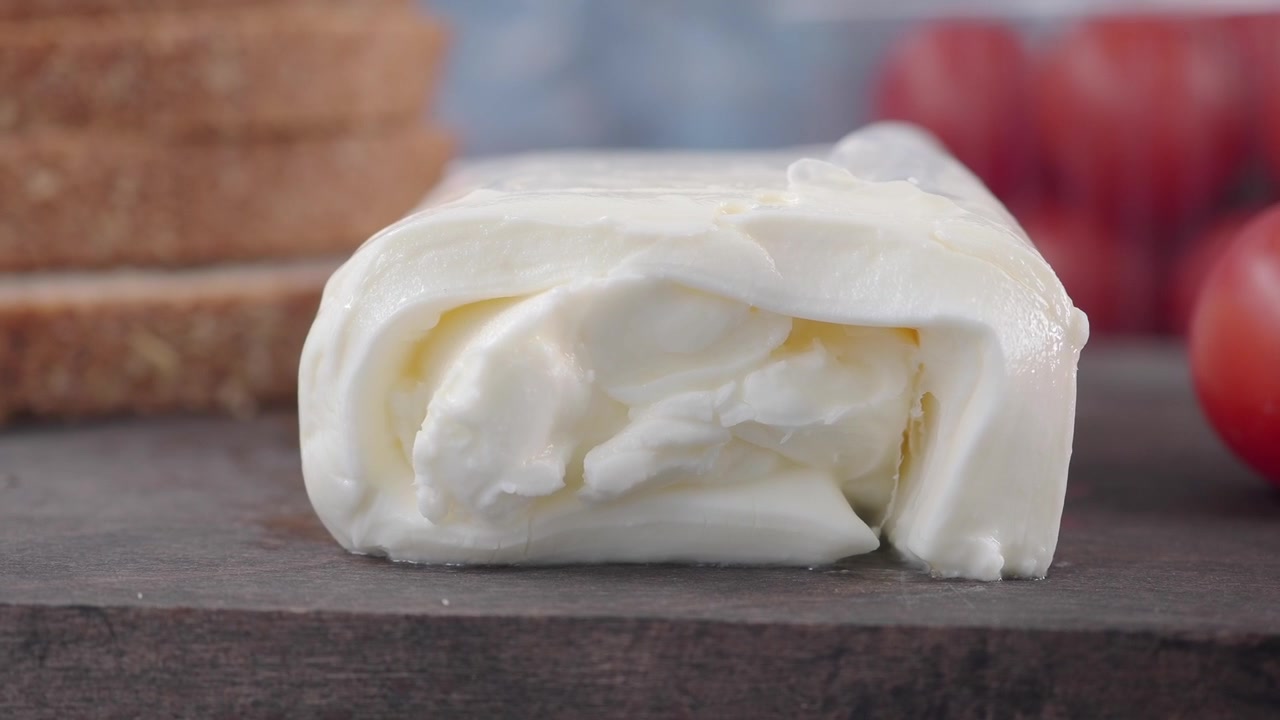 Blocco di mozzarella fresca su tagliere di legno.