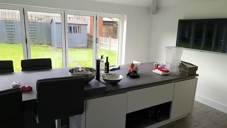 spacious contemporary designer kitchen island counter with bright patio family garden