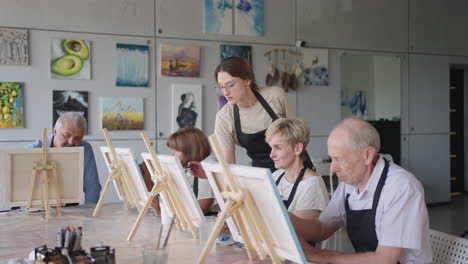 like senior friends attending together at a painting class. small group taking a variety of fun classes together. a group of elderly people attend a master class on drawing together spending time.