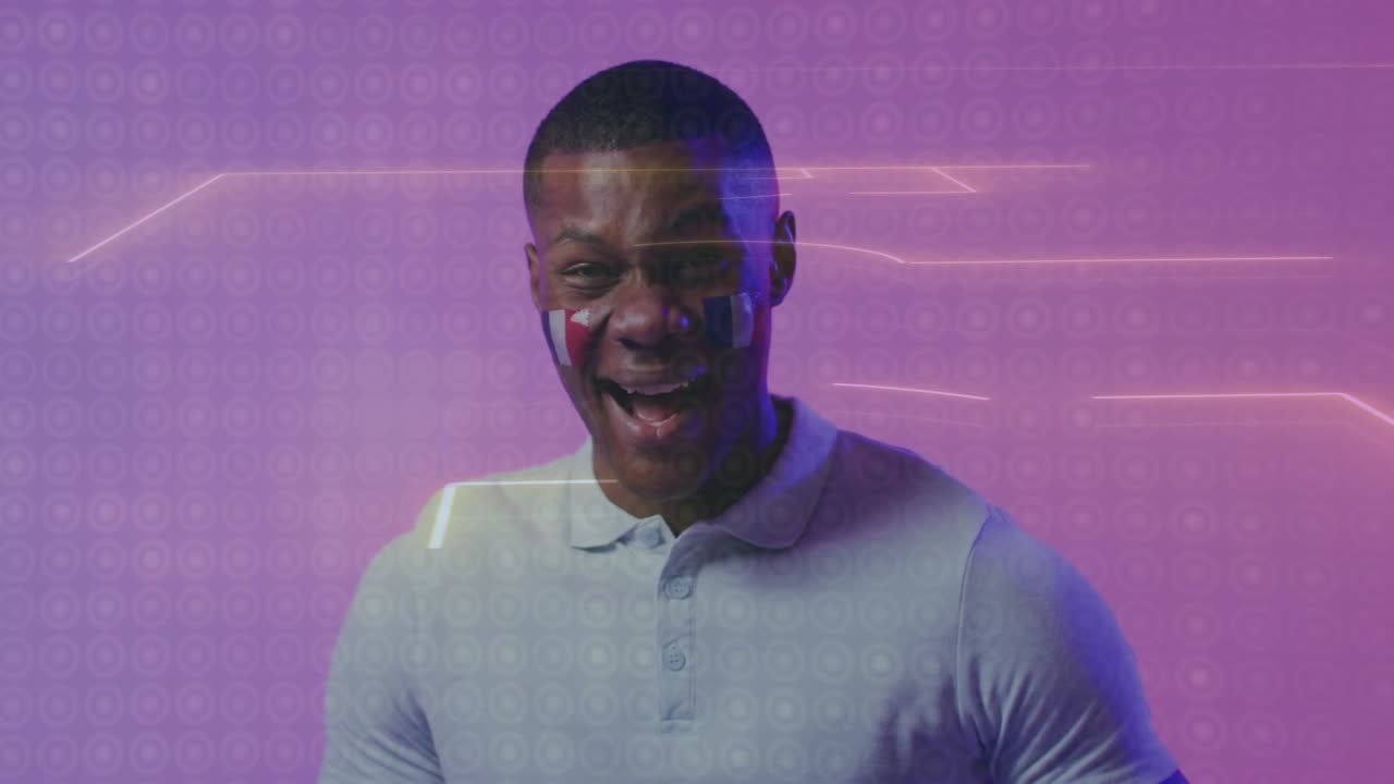 Male fan holding soccer ball, wearing face paint, neon pitch lines sweeping, initiating laughter