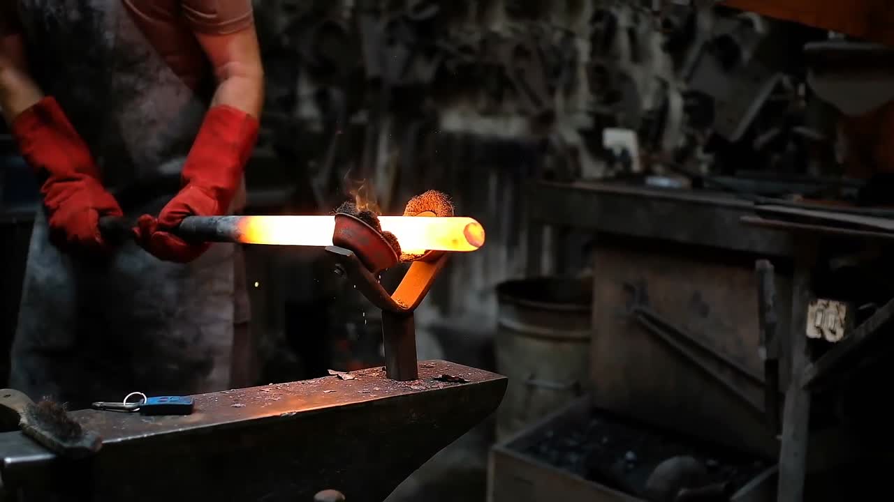 Blacksmith forging the molten metal with hammer machine 4k