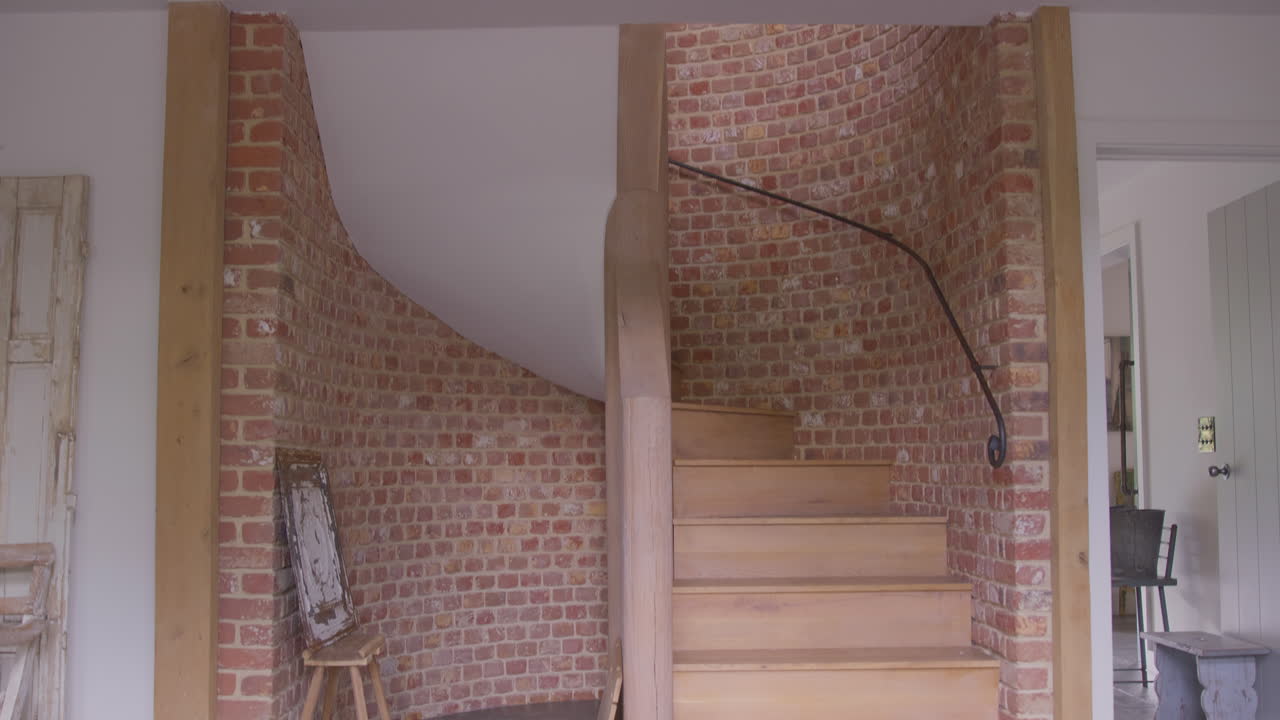 galería de madera y escalera con paredes de ladrillo expuestas en una casa o apartamento moderno de planta abierta