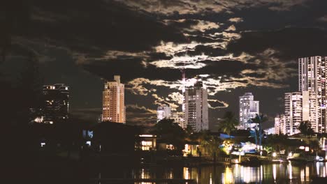 time-lapse of moon rising above cityscape at night