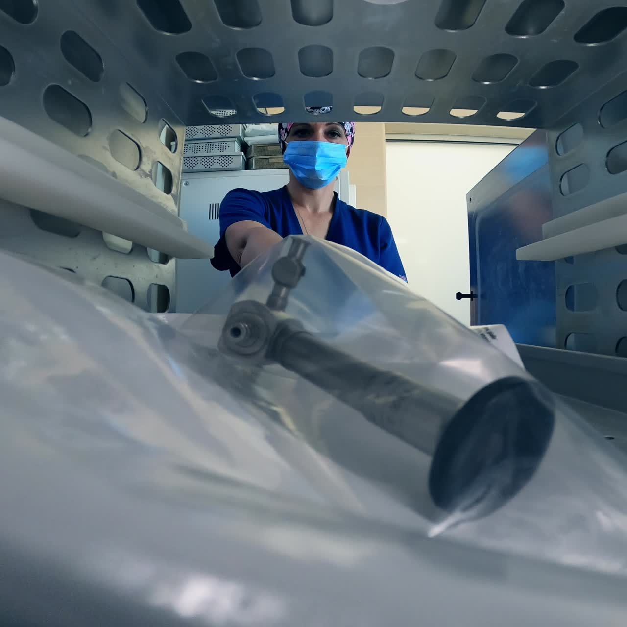 Placing instruments packed into plastic bag to a sterilizer machine. Looking at the interior of a sterilizing equipment from inside
