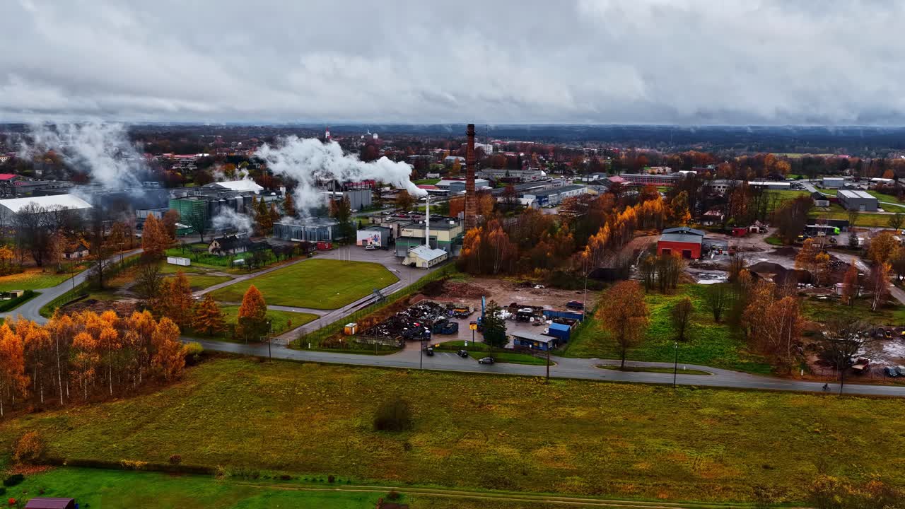 Aerial: Cesis cityscape with plant and construction site during the day in Latvia, pan drone shot