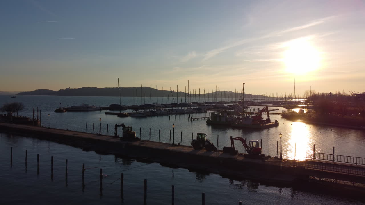Sunset over Balatonfured marina with boats docked and golden light reflecting off calm lake