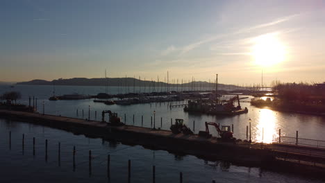 sunset over balatonfured marina with boats docked and golden light reflecting off calm lake