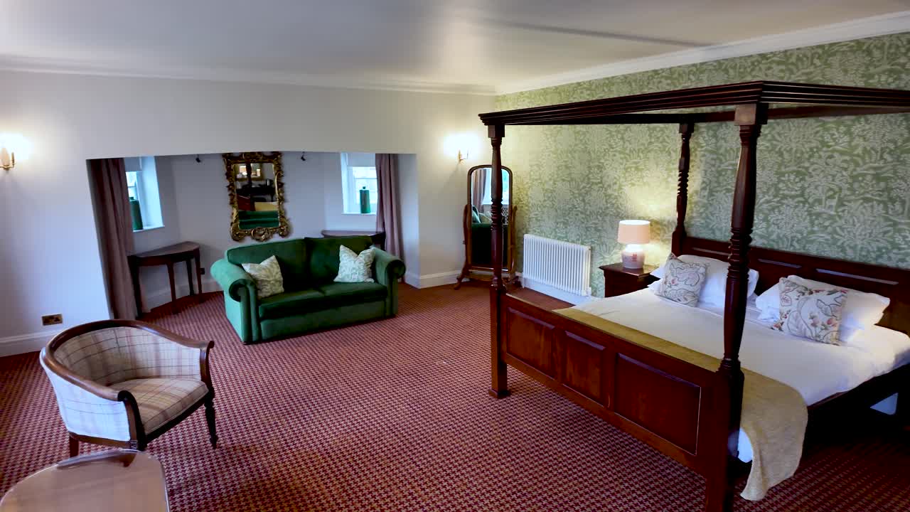 Elegant Four Poster In Large Bedroom Of English Manor House With Green Sofa Antique Mirror And Floral Wallpaper For Luxury Travel And Interior Design