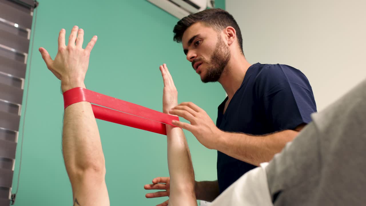 Fisioterapeuta Orientando Paciente em Exercícios de Braço com Faixa de Resistência