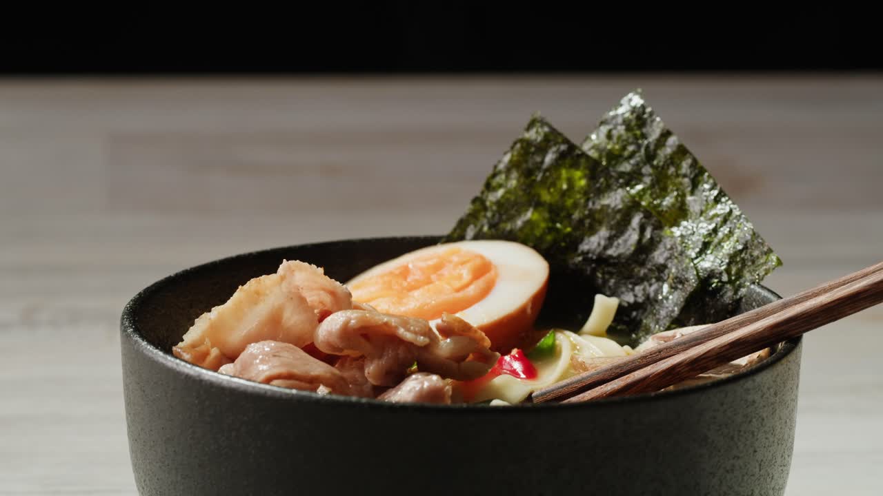 un delicioso plato de ramen con carne de cerdo, huevo y algas
