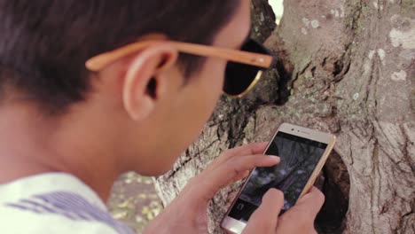 young-man-using-his-cell-phone-to-take-photos-of-nature