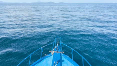 a boat glides smoothly over calm ocean waters near phuket, thailand, under clear skies and bright sunlight