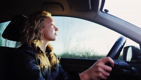 mujer conduce el auto al atardecer 1