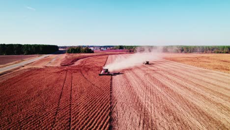 Combine-harvesters-gathering-crops-in-Georgia,-dust-clouds-billowing