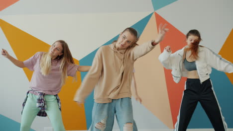 group of young women dancing in a colorful studio