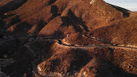 Aerial-tracking-of-cars-driving-along-mountain-road-in-El-Paso,-TX