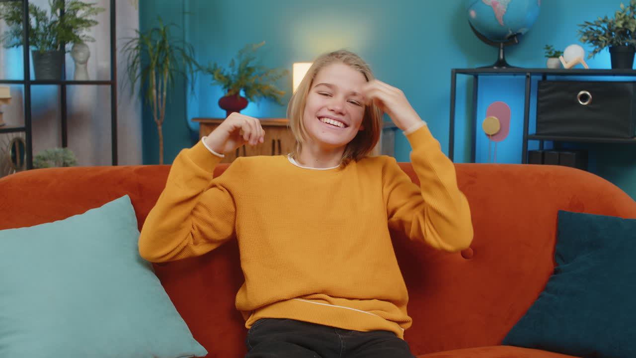 niño adolescente viendo la televisión celebrando la victoria animando al equipo deportivo sentado en el sofá en casa