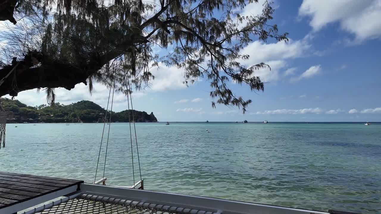 열대 섬 파라다이스의 해안선에 햄록과 목조 스을 가진 럭셔리 호텔 갑판, 평온하고 은 바다 물의 지평선으로의 전망