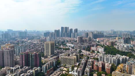 aerial daytime view of shenzhen's cityscape, a sprawling urban environment filled with high-rise buildings. the bustling metropolis is set against the sky, highlighting its modern architecture. china