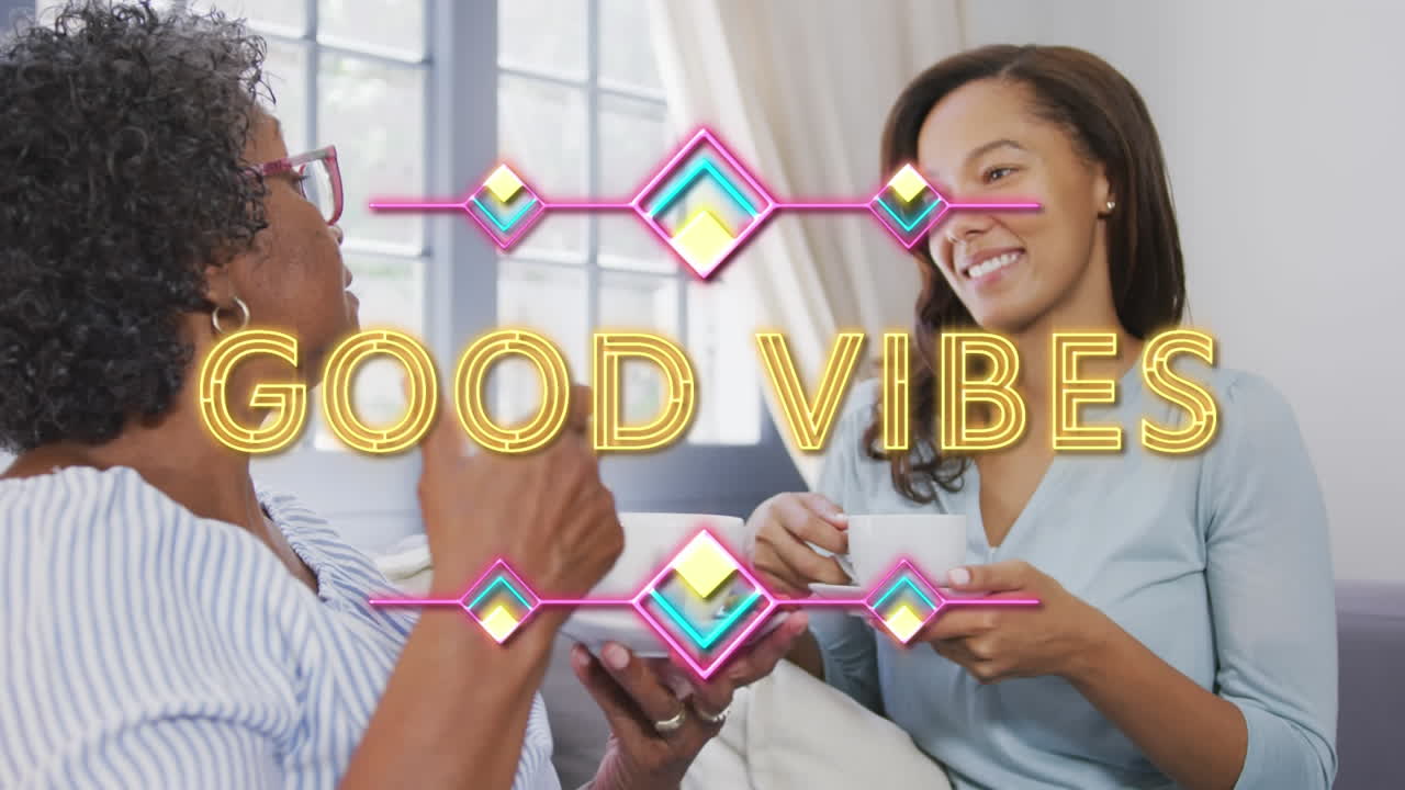 animación de texto de buenas vibraciones sobre dos mujeres tomando té y sonriendo en casa