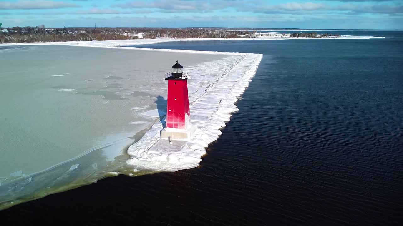 Red Manistique, Michigan Lighthouse during sunny winter day.
