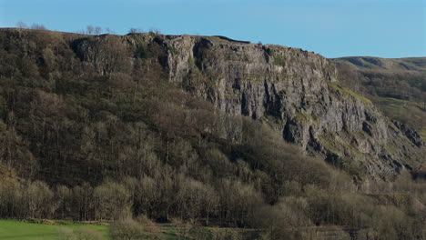 establishing drone shot of steep cliff rock face and trees yorkshire