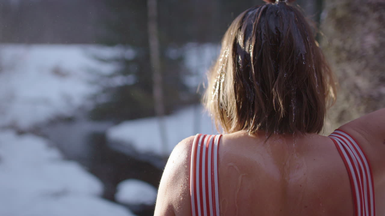 Rinsing sweat and toxins off after sauna with scoop of icy cold water on head