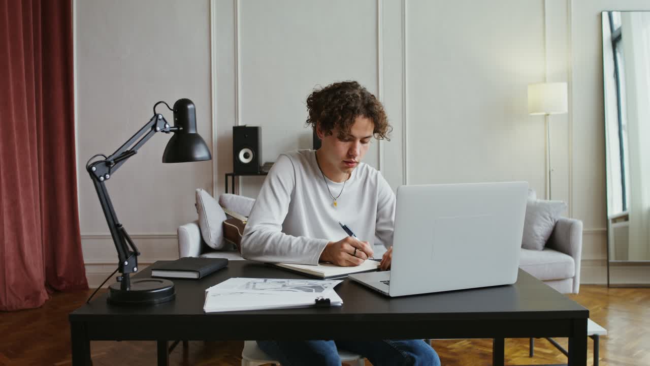 joven estudiando y dibujando en casa