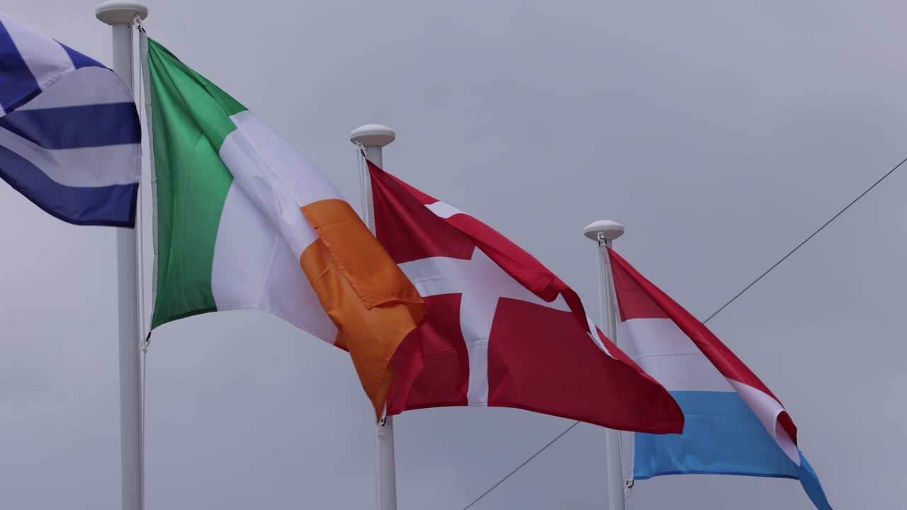 Ireland Denmark and Luxembourg flags blowing in the wind in slow motion