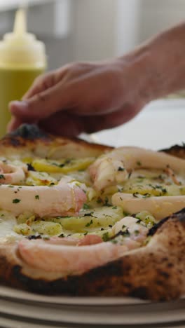 chef putting last bit of oil on top of the hot octopus pizza