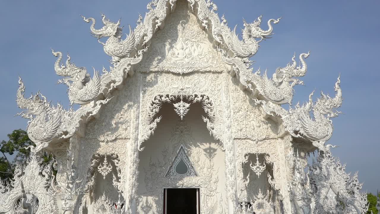 Tilt revelation of the White Temple main entrance to the prayer house at Chiang Rai, Thailand.