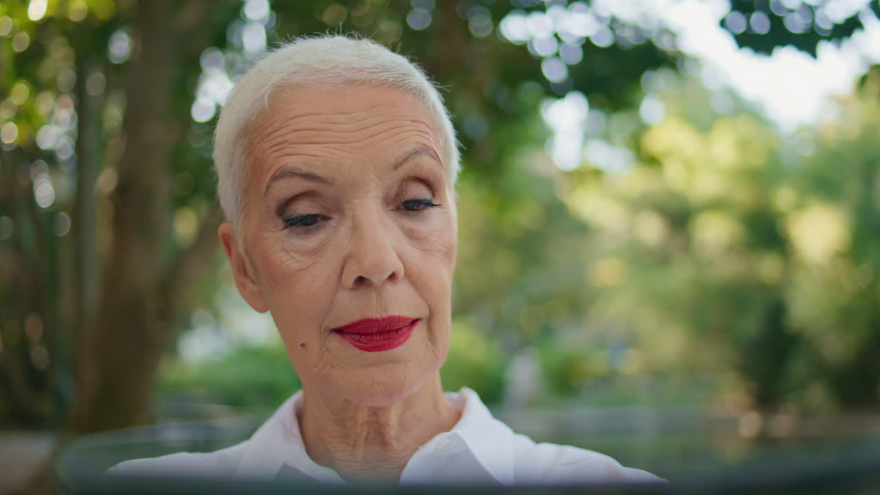 Elderly businesswoman reading magazine portrait. Beautiful mature woman in park
